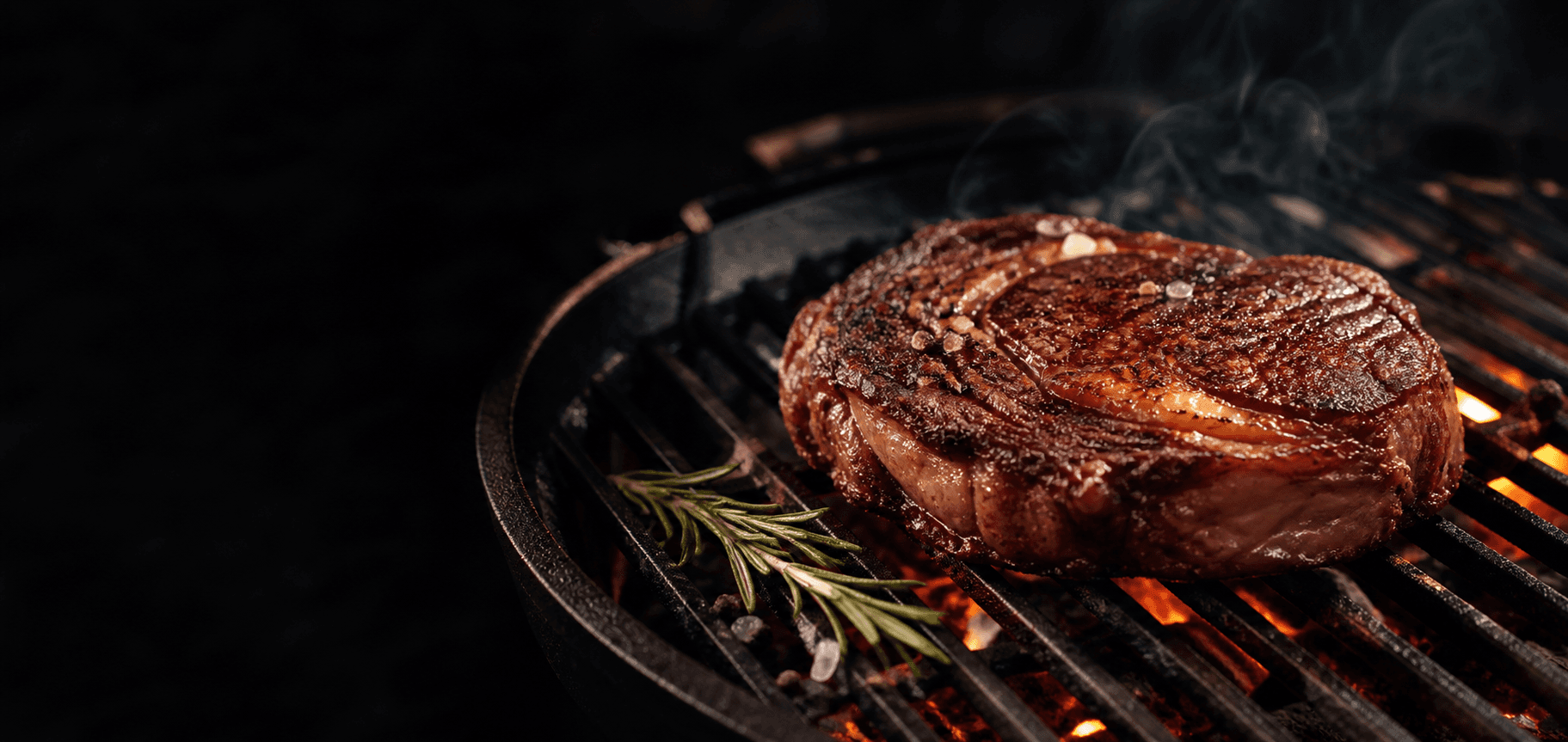 Ribeye op een gietijzeren grill boven gloeiende kolen